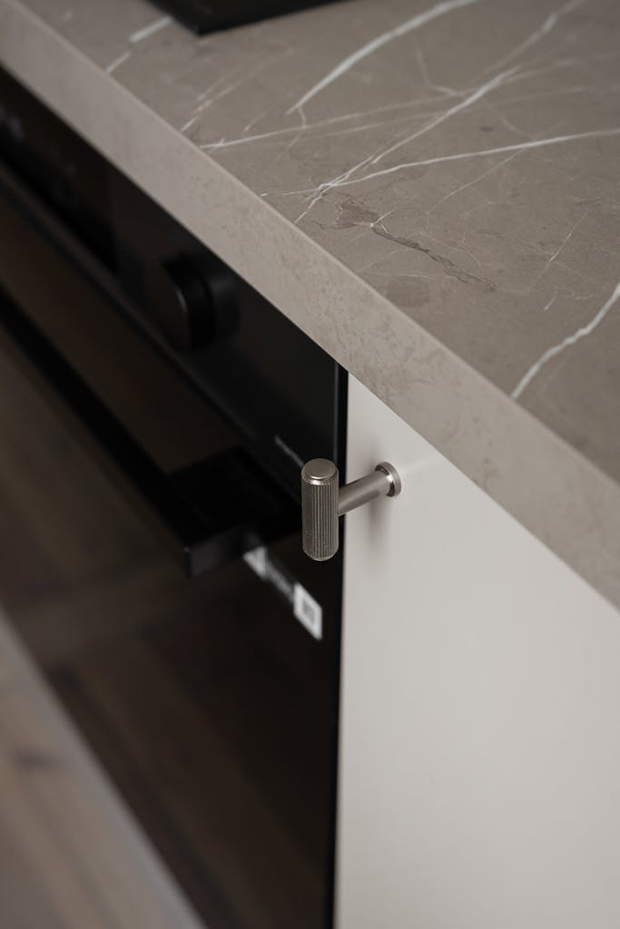 Elegant kitchen countertop design featuring a sleek oven handle and marble finish.